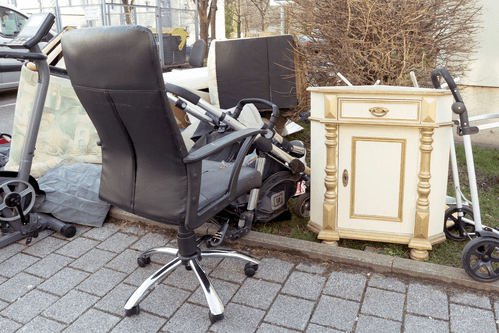 A broken chair is discarded with other junk types